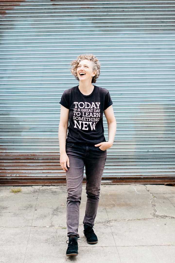 Eva laughing wearing a black tshirt that reads Today is a great day to learn something new